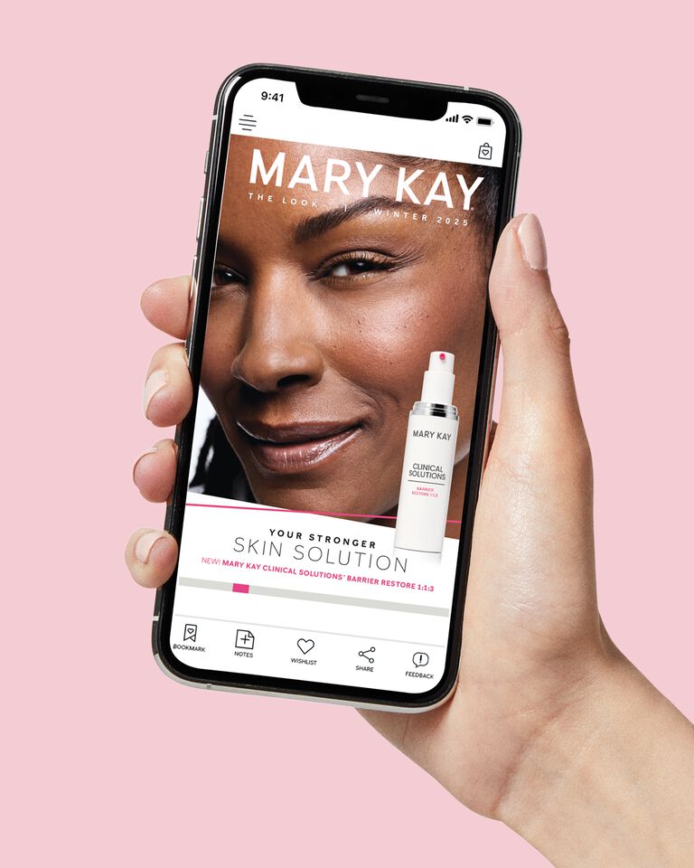 Hand holding a phone showing the Mary Kay Winter 2025 Look digital catalog.